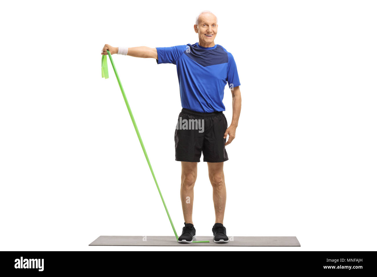 Portrait d'un haut standing sur une natte et s'exercer avec une bande de caoutchouc isolé sur fond blanc Banque D'Images