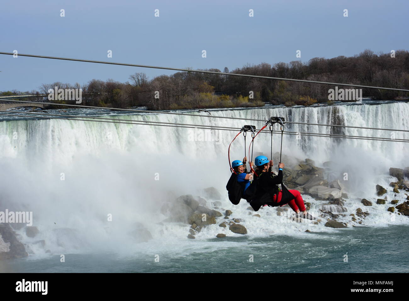 Deux femelles du Mistrider WildPlay ride à la tyrolienne au-dessus des chutes de la rivière Niagara à Niagara Falls, Ontario, Canada. Banque D'Images