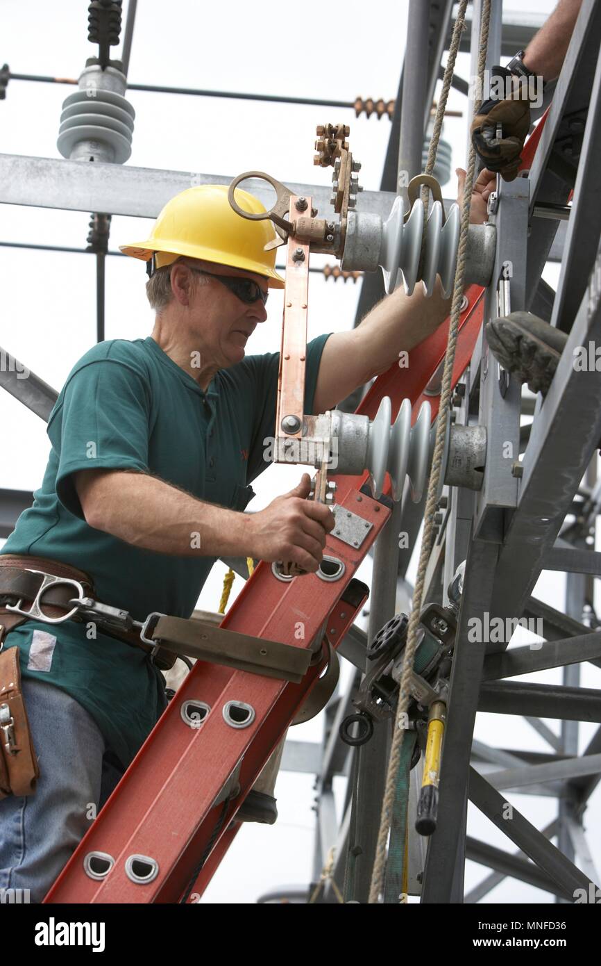 Poseur de l'installation Nouvelle ligne pour tenir compte de l'amélioration de la ferme de panneaux solaires le réseau électrique Banque D'Images