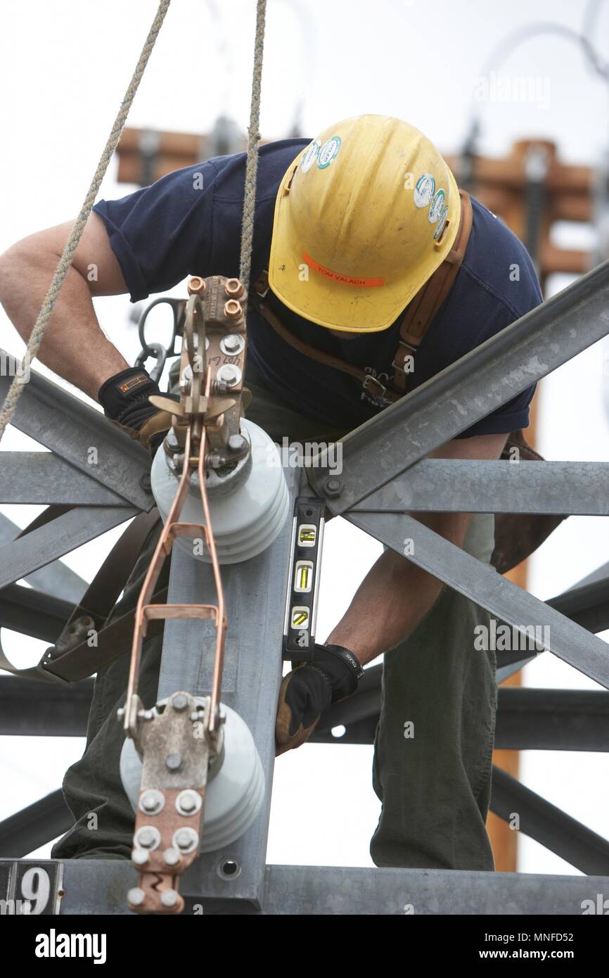 Poseur de l'installation Nouvelle ligne pour tenir compte de l'amélioration de la ferme de panneaux solaires le réseau électrique Banque D'Images