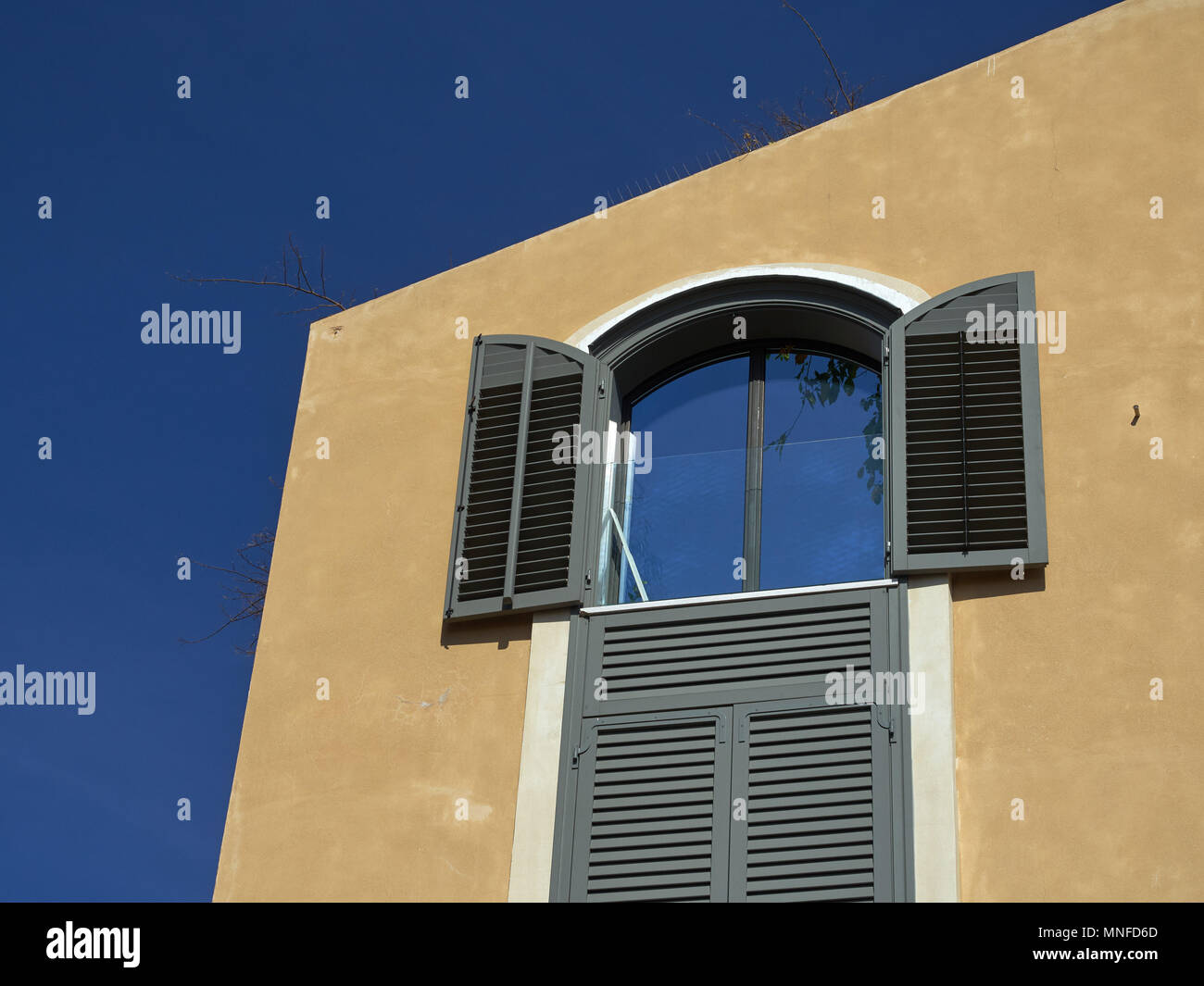 Maison ancienne, peint en jaune, dans les fenêtres de la fenêtre ouverte, le ciel bleu, Jérusalem, Israël se reflète. Banque D'Images