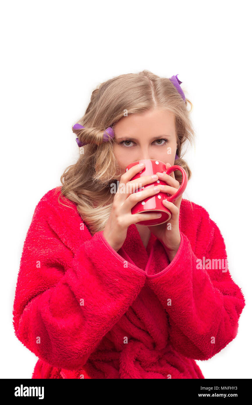 Jeune fille dans une robe rouge de curling et de boire le thé du matin Banque D'Images