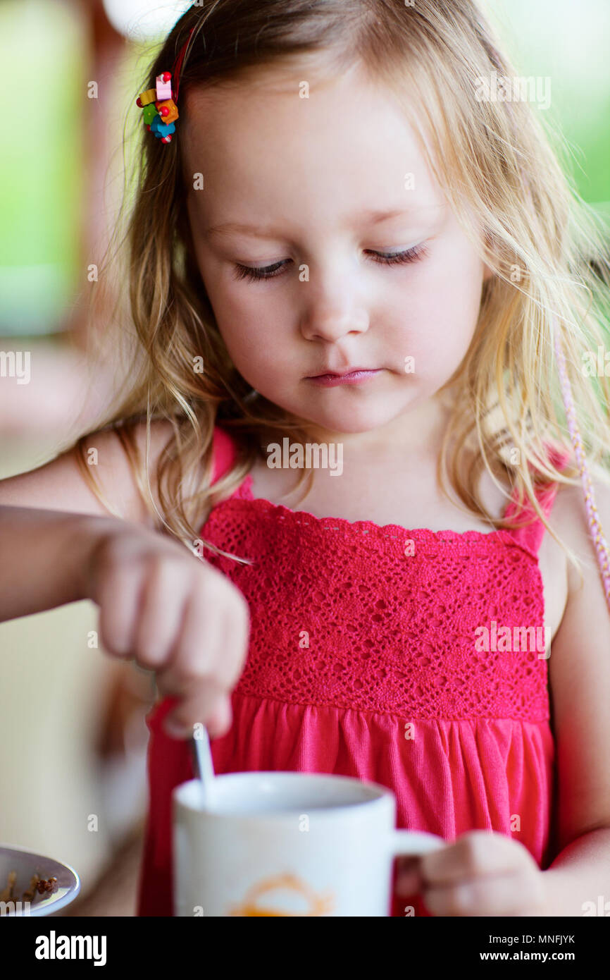Adorable petite fille dans le boire du chocolat chaud Banque D'Images