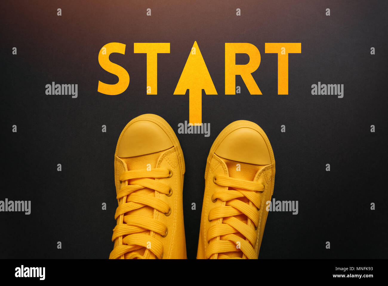 Debout à la ligne de départ de l'image conceptuelle avec personne dans sneakers jaune, vue du dessus Banque D'Images