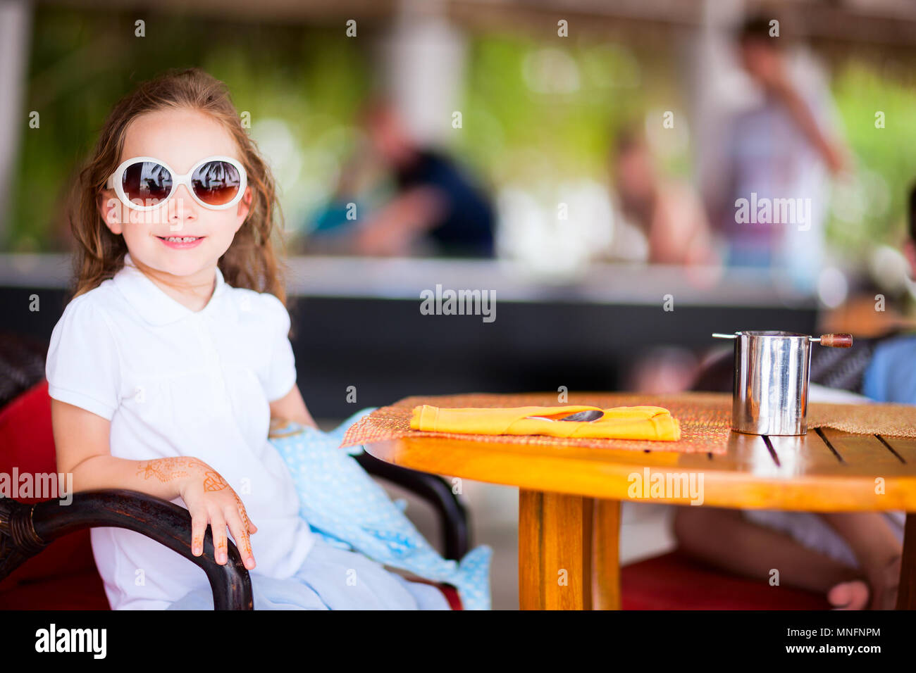 Adorable petite fille dans le café en plein air journée d'été Banque D'Images