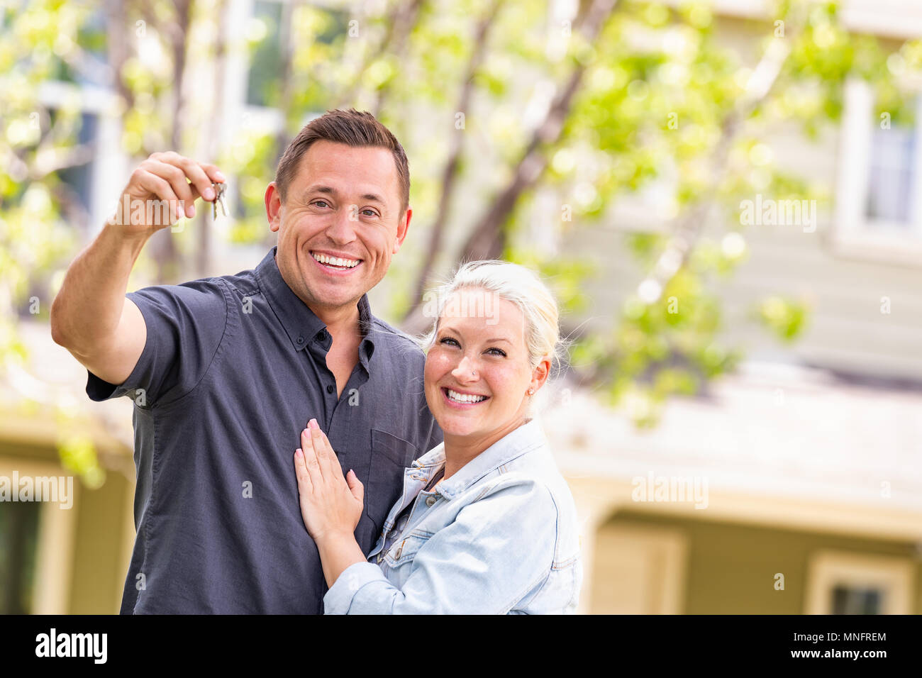 Caucasian Couple in Front of House avec les touches. Banque D'Images