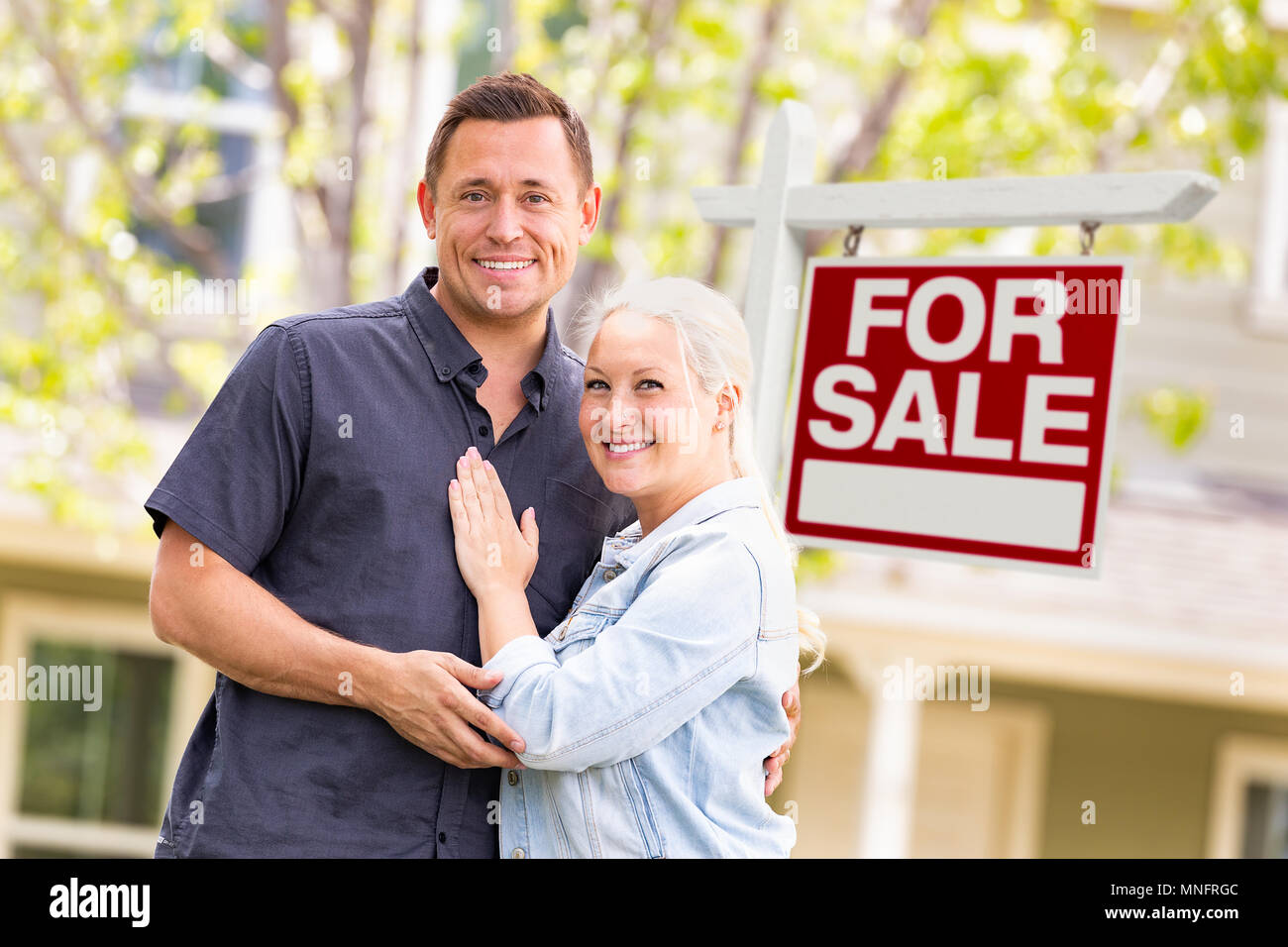 Caucasian Couple in front of a vendre enseigne immobilière et de la chambre Banque D'Images