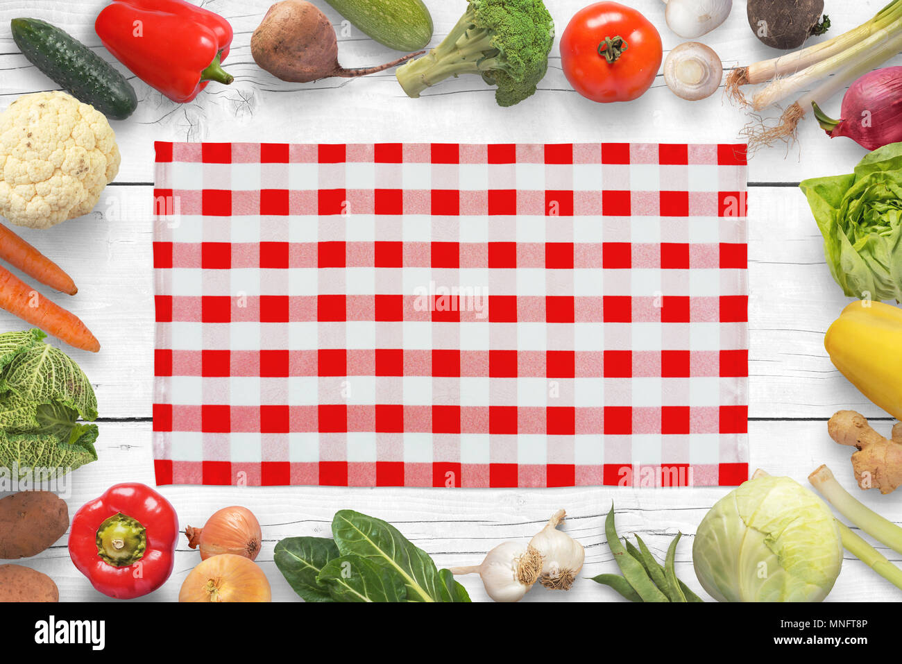 Nappe blanche rouge traditionnel sur table de cuisine entouré de légumes. Banque D'Images