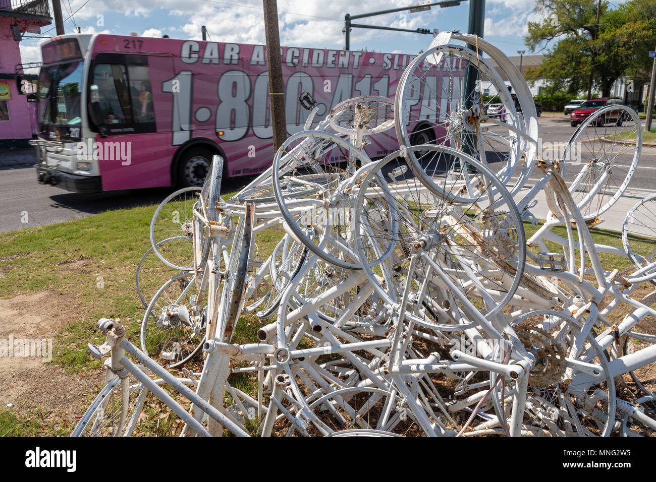 La Nouvelle-Orléans, Louisiane - un bus peint avec publicité à propos des accidents de la circulation entraîne par un ghost bike sculpture. La sculpture commémore bicyclist Banque D'Images