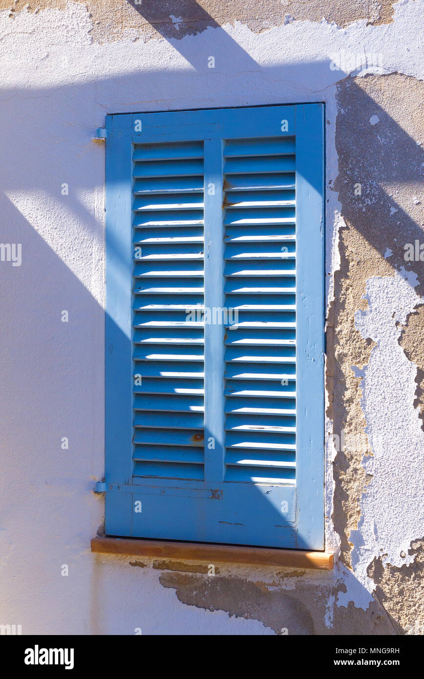 Une fenêtre bleue shutter orne une maison à Cala San Vincente sur l'île espagnole de Majorque. Banque D'Images