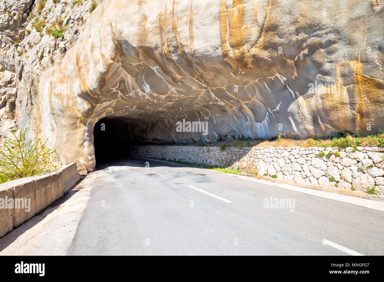 Tunnel sculpté dans la pierre sur la crête de la montagne près de Mlini vue, routes dangereuses de la Croatie Banque D'Images