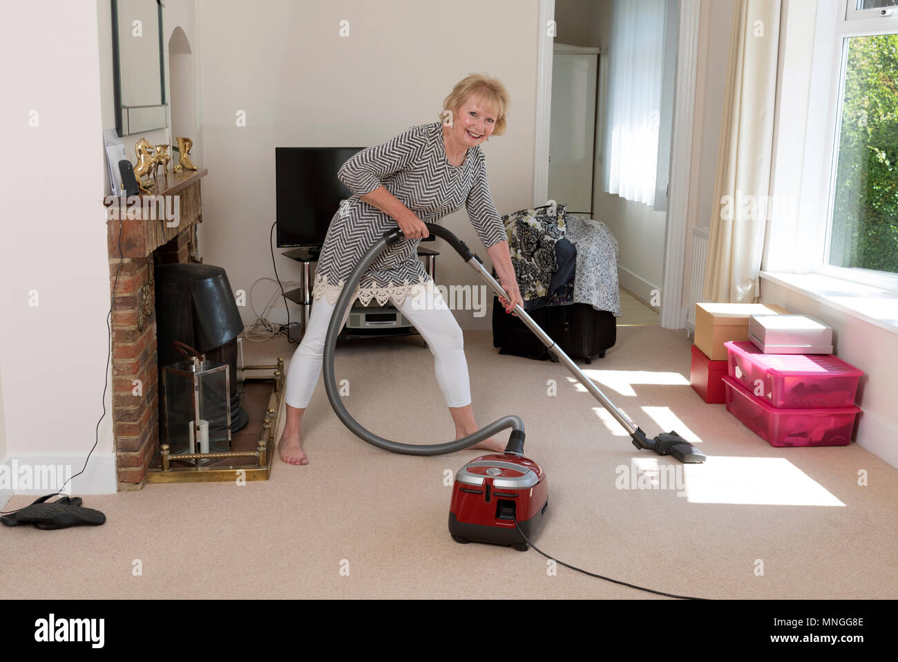 Déménagement, femme à l'aide d'un aspirateur pour aspirateur très hoover le tapis avant de déménager hors de la propriété. Banque D'Images