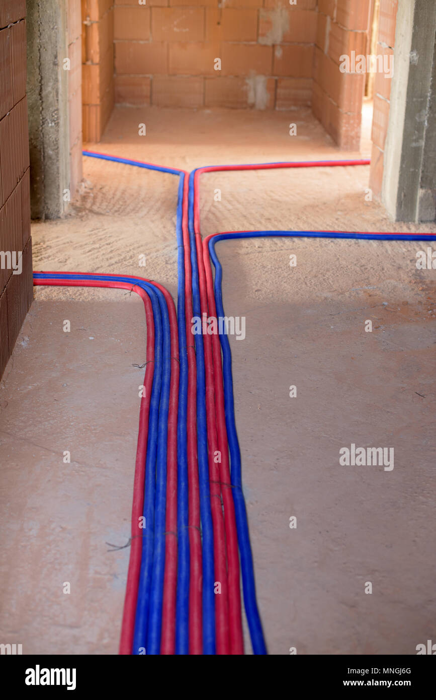 Deux tuyaux colorés, bleu et rouge, à l'étage - chauffage installation Banque D'Images
