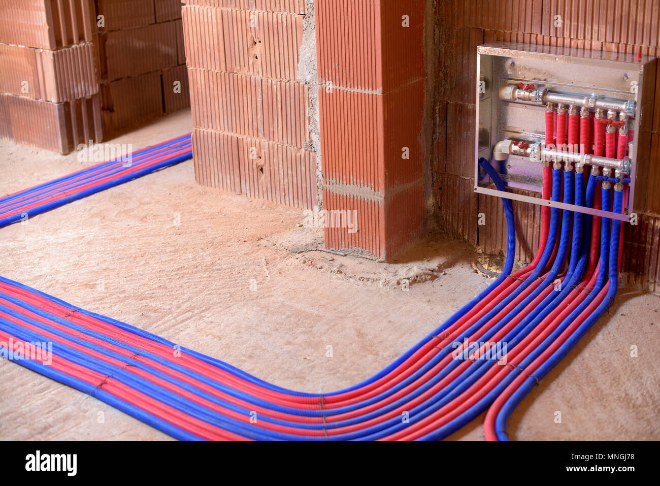 Les tuyaux de plancher en deux couleurs, rouge et bleu, et le panneau de commande. Banque D'Images