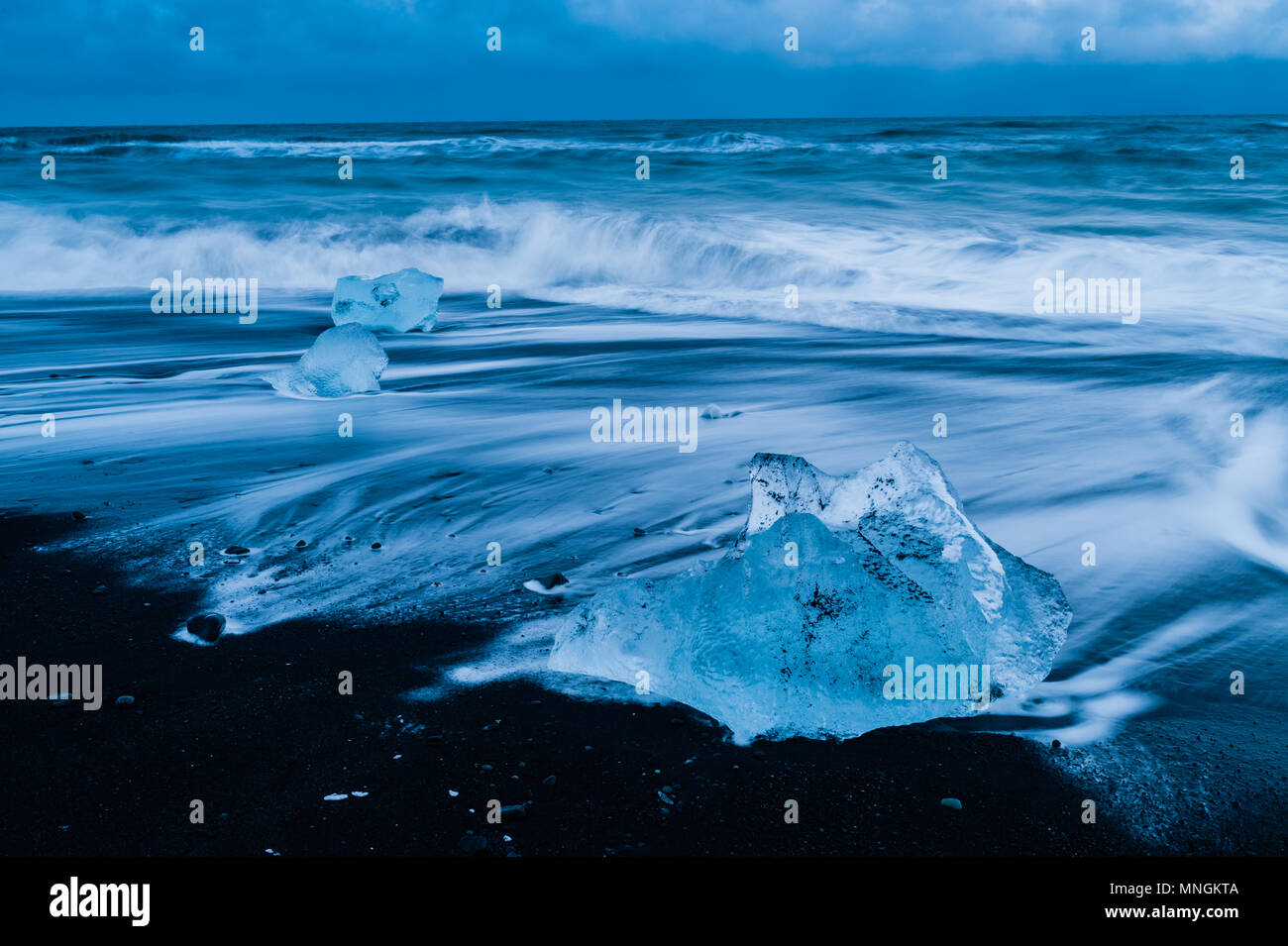 Rochers de glace baignées par la prochaine surf de l'océan Atlantique à sable volcanique noir à diamond beach, l'Islande avril 2018 Banque D'Images