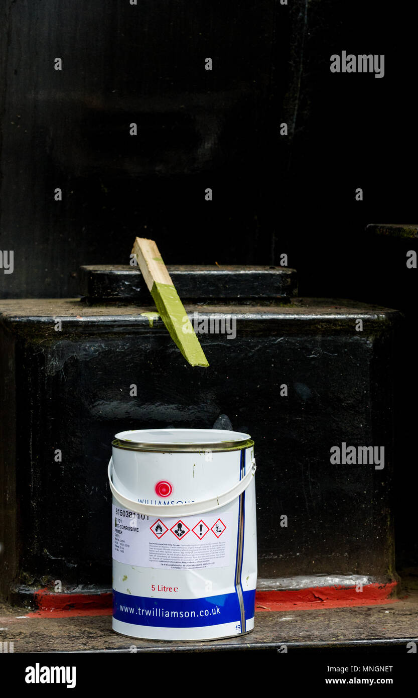 Tin de peinture verte avec stick en remuant. Banque D'Images