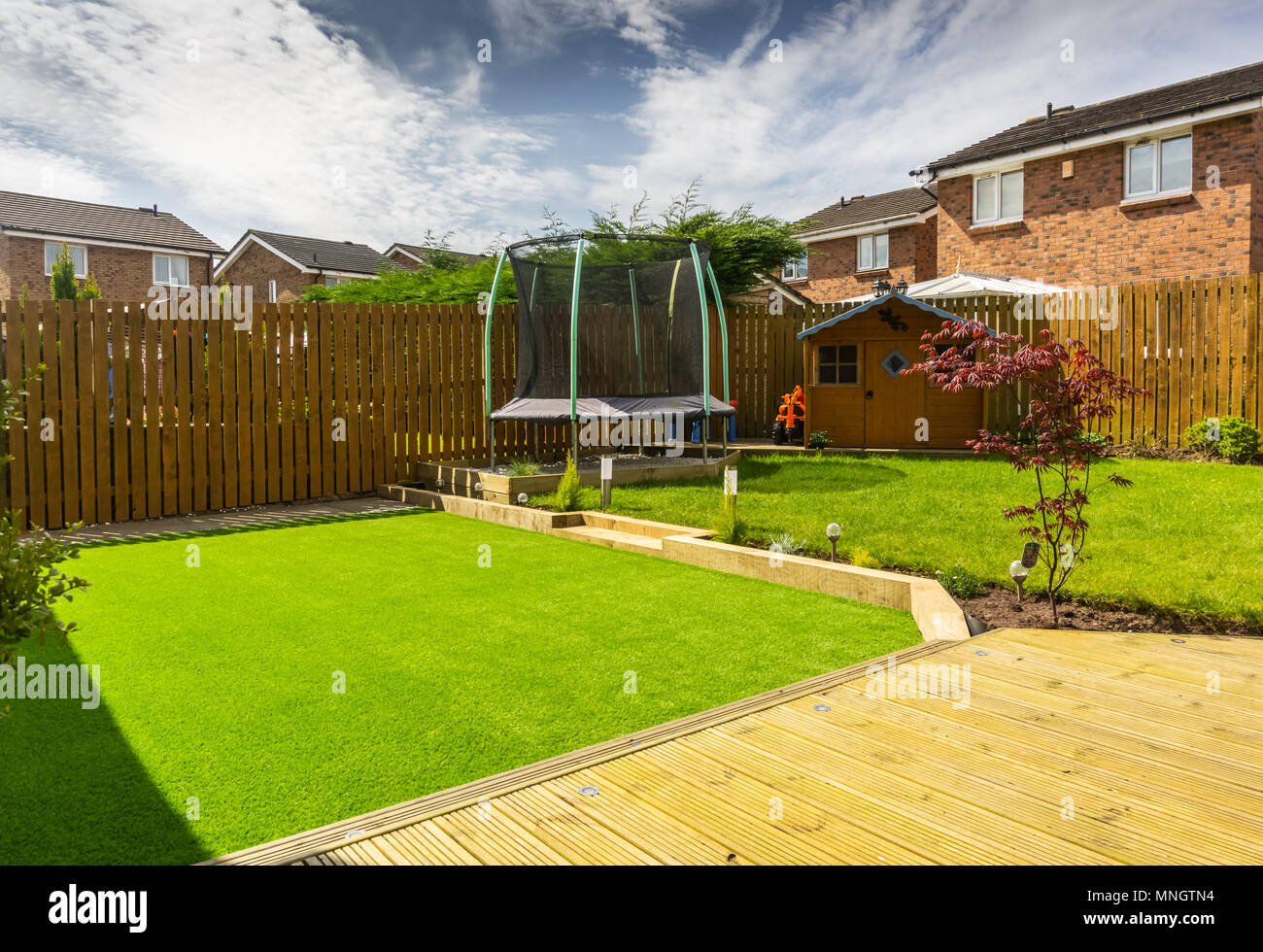 Un jardin moderne avec une nouvelle lame de pelouse plantée d'arbustes et de frontières. Conçu et administré par cotisant. Une bonne image pour paysage gardiners ou desig Banque D'Images