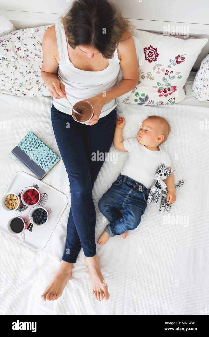 Mere Et Enfant Bebe Garcon Au Lit Maman Bebe Dormir Lire Un Livre Et Manger Des Fruits Et De La Creme Glacee High Angle Shot D En Haut Heureux Famil Photo Stock Mere Et Enfant Bebe Garcon Au Lit Maman Bebe Dormir Lire Un Livre Et Manger Des Fruits Et De La Creme Glacee High Angle Shot D En Haut Heureux Famil Photo Stock