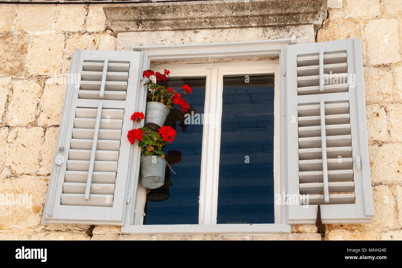 Fenêtre avec volets en bois et de fleurs Banque D'Images