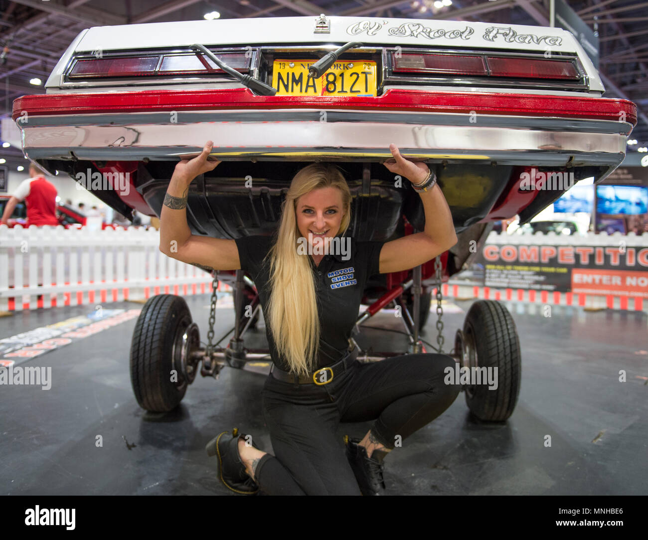 ExCel, Londres, Royaume-Uni. 17 mai, 2018. L'Confused.com London Motor Show event se déroule du 17 au 20 mai 2018 avec un espace 4,5 fois plus grand que l'an dernier. Photo : Jeune femme semble soulever une voiture personnalisée sur le Motor Show Events stand. Credit : Malcolm Park/Alamy Live News. Banque D'Images