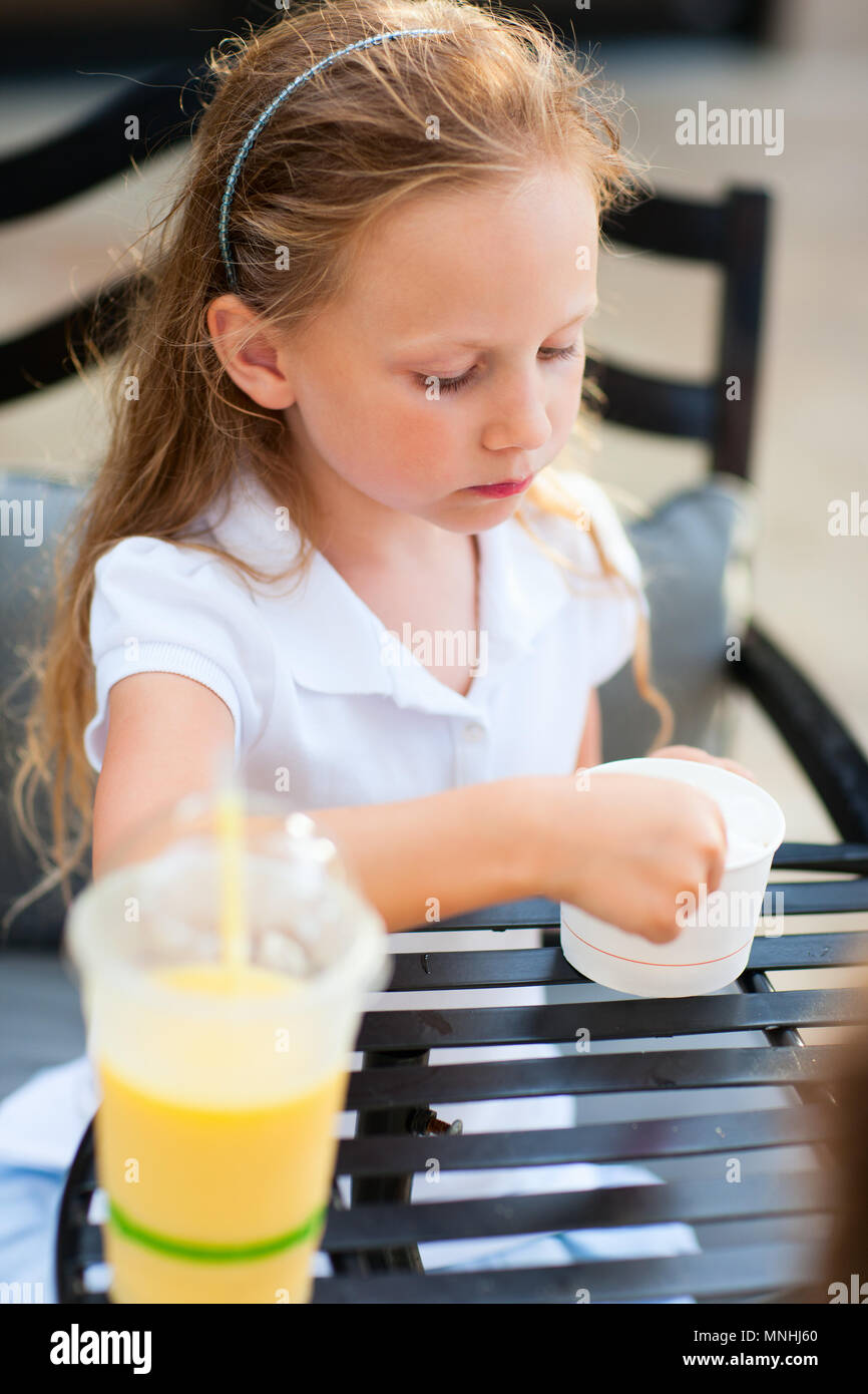 Little girl eating ice cream au café en plein air Banque D'Images