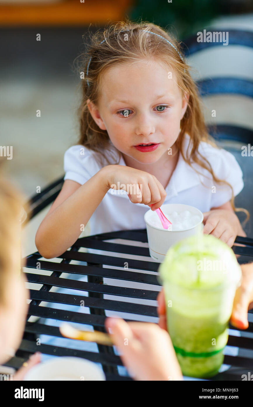 Little girl eating ice cream au café en plein air Banque D'Images