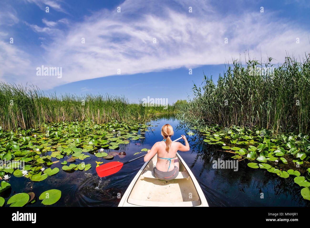 Woman sailing dans Delta du Danube avec un bateau Banque D'Images