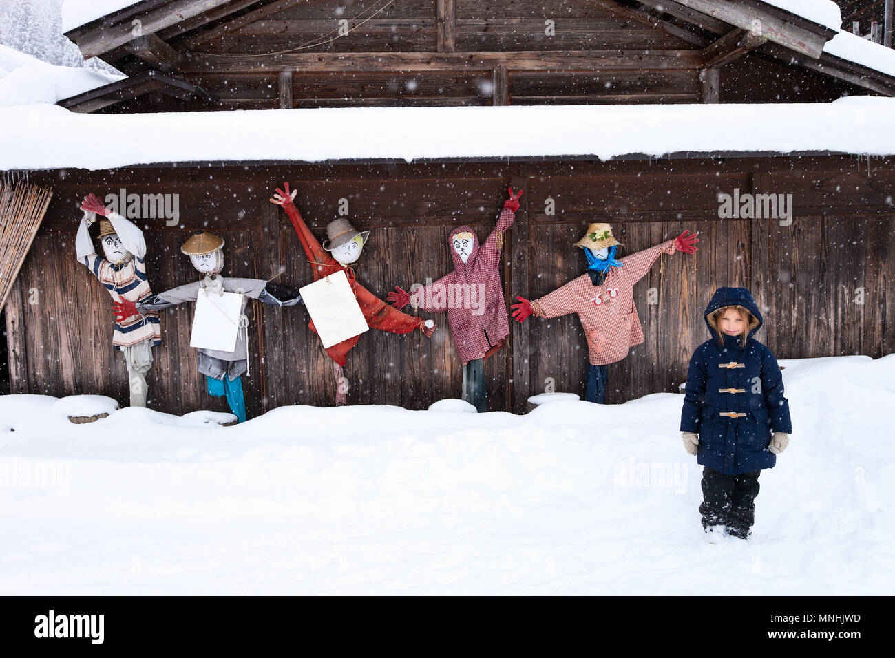 Petite fille avec drôle épouvantails à l'historique village japonais Shirakawa-go à l'hiver, l'un des sites du patrimoine mondial de l'UNESCO Banque D'Images