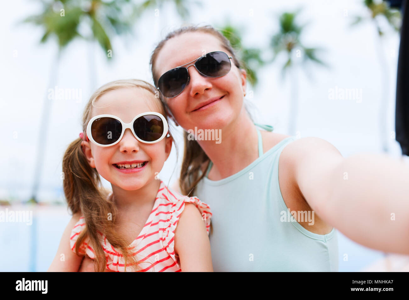 Famille heureuse mère et son adorable petite fille en vacances en tenant avec smartphone selfies Banque D'Images