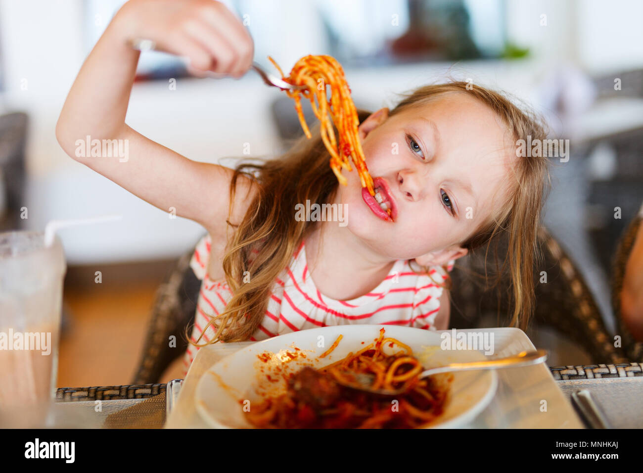 Portrait de l'adorable petite fille mange du spaghetti pour un déjeuner au restaurant Banque D'Images