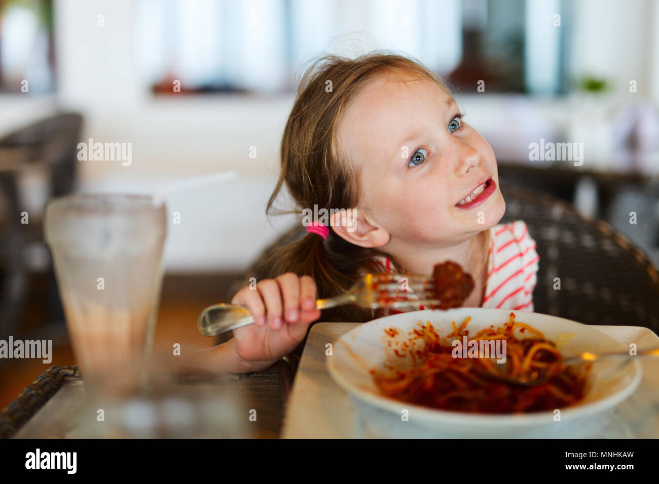 Portrait de l'adorable petite fille mange du spaghetti pour un déjeuner au restaurant Banque D'Images