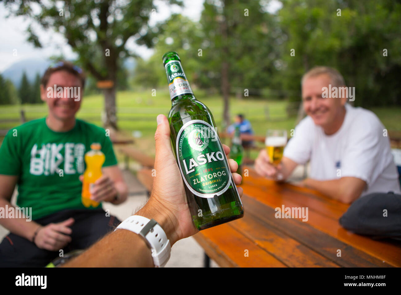 Trois randonneurs se réjouissent avec de la bière au refuge de montagne en Uskovnica, pâturage d'altitude sur le plateau de Pokljuka dans les Alpes Juliennes, en Slovénie Banque D'Images