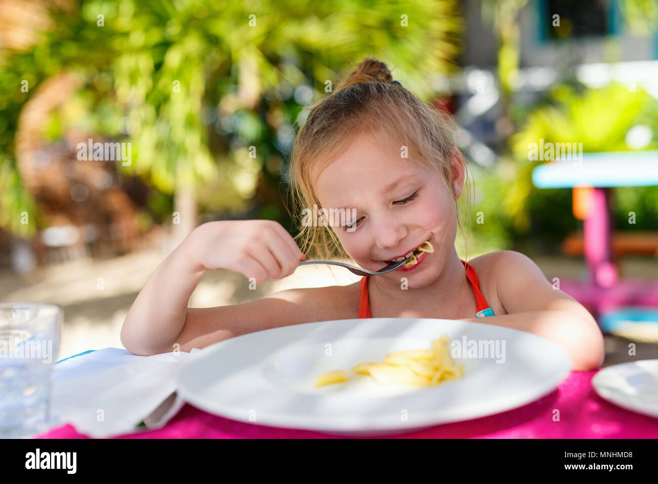 Portrait de l'adorable petite fille de manger des pâtes pour un déjeuner au restaurant Banque D'Images