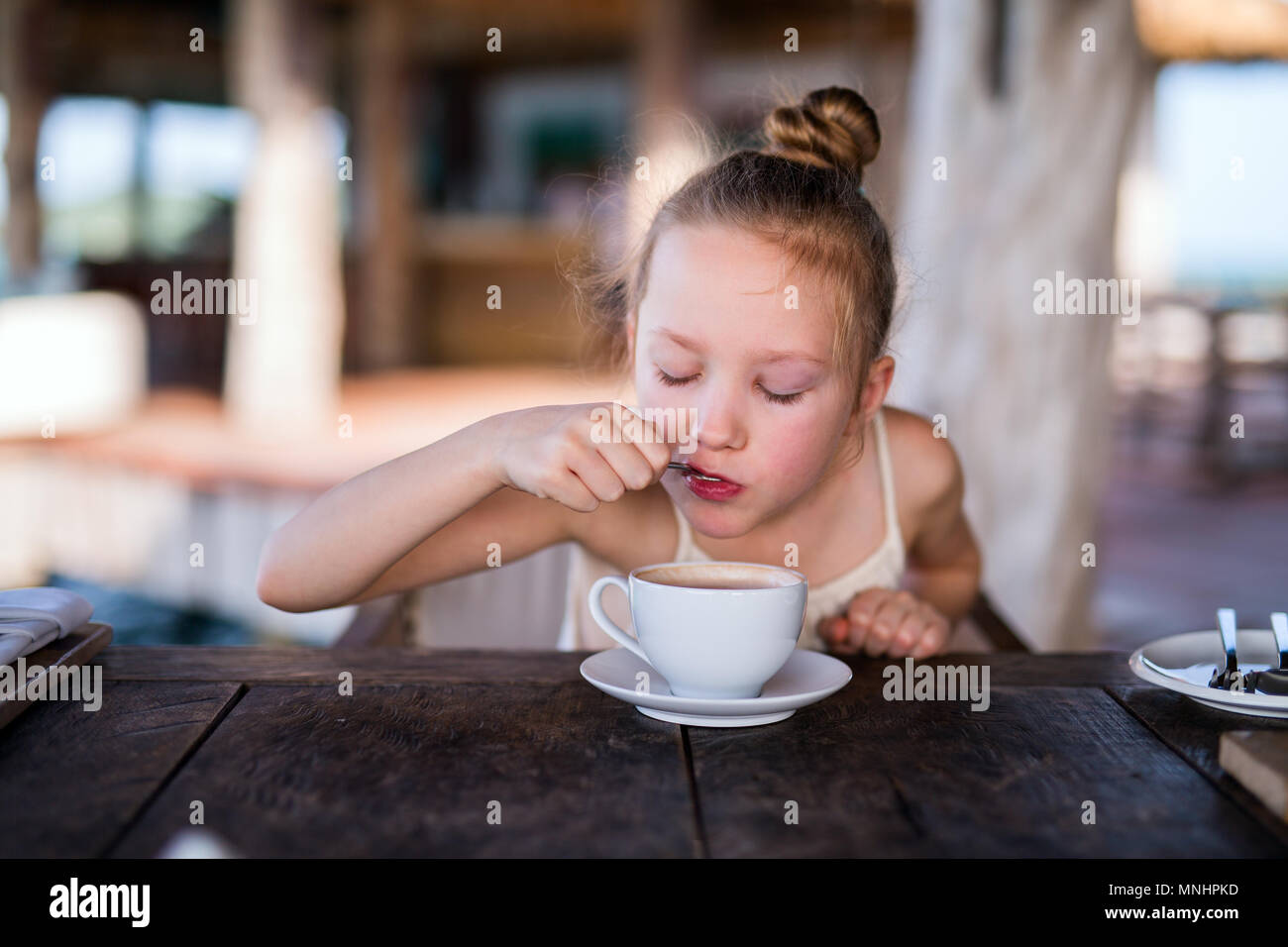 Adorable petite fille dans le boire du chocolat chaud Banque D'Images