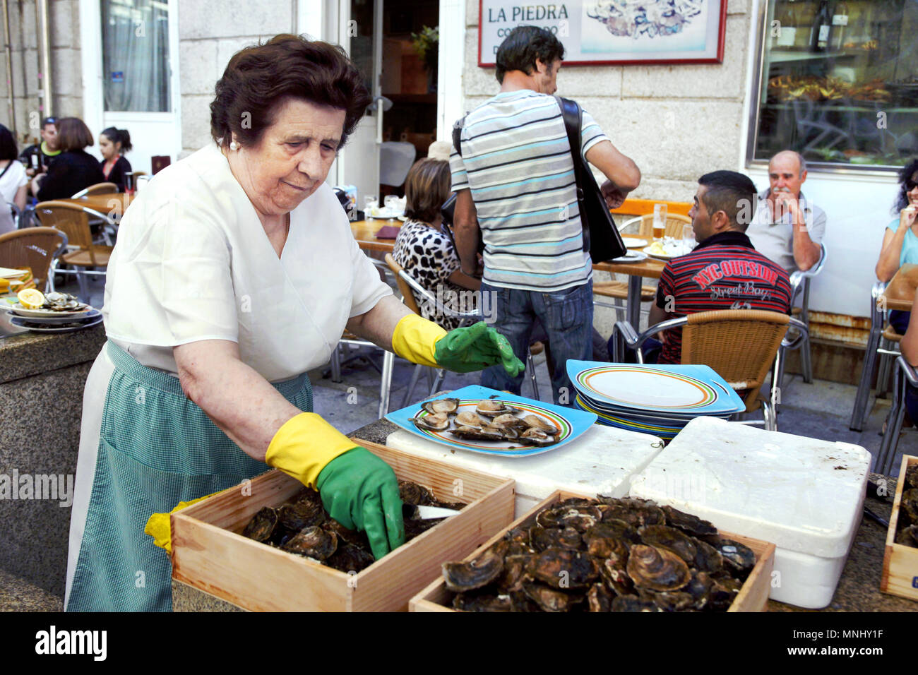Ouvrir les huîtres, femme Cocedero Bar restaurant La Piedra, Rúa Pescadería ou rue Rua das Ostreiras / rue de l'huître, la Piedra, Vigo, Galice, Espagne Banque D'Images