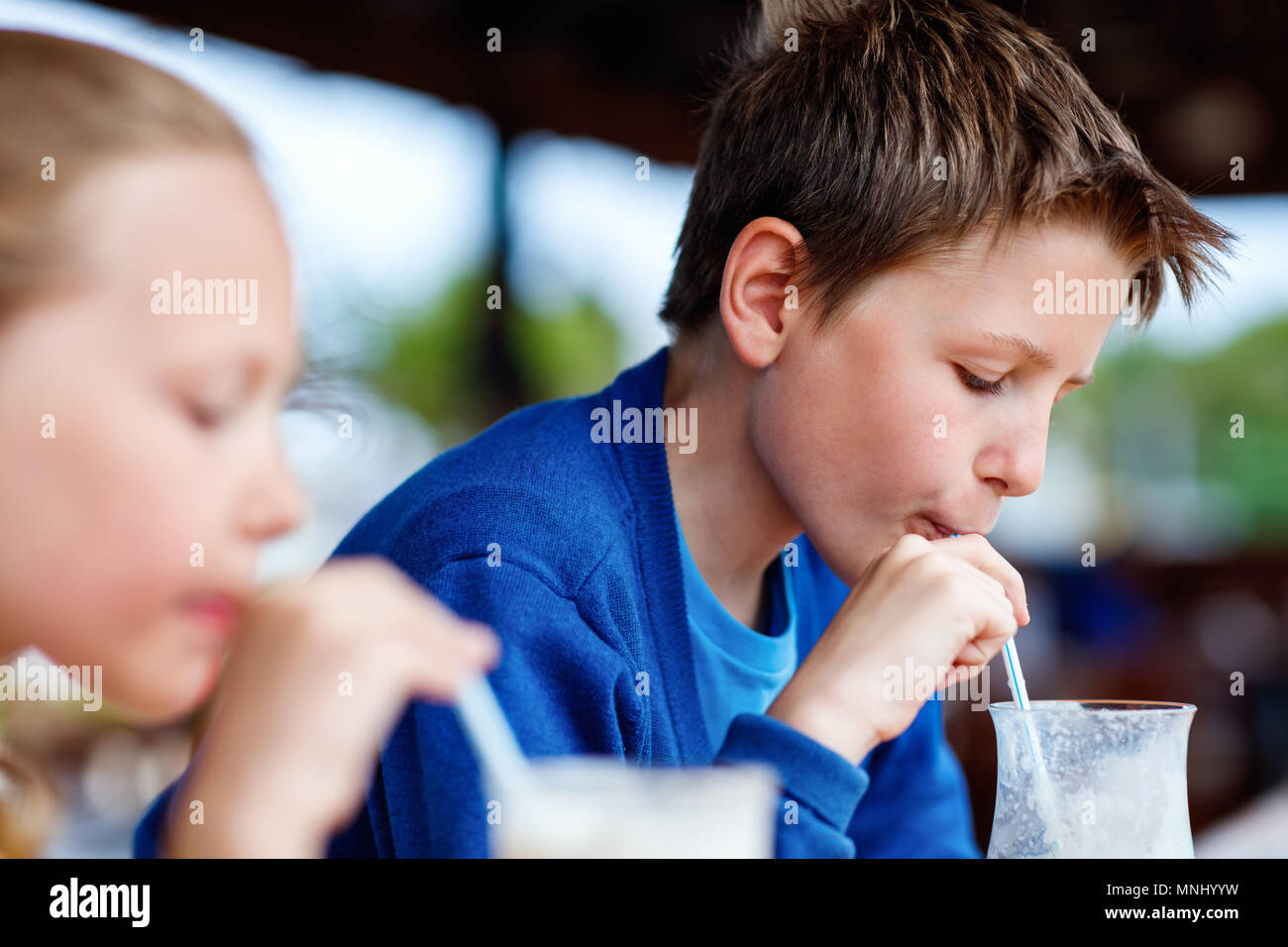 Les jeunes frère et sœur de lait frappé au café en plein air potable Banque D'Images