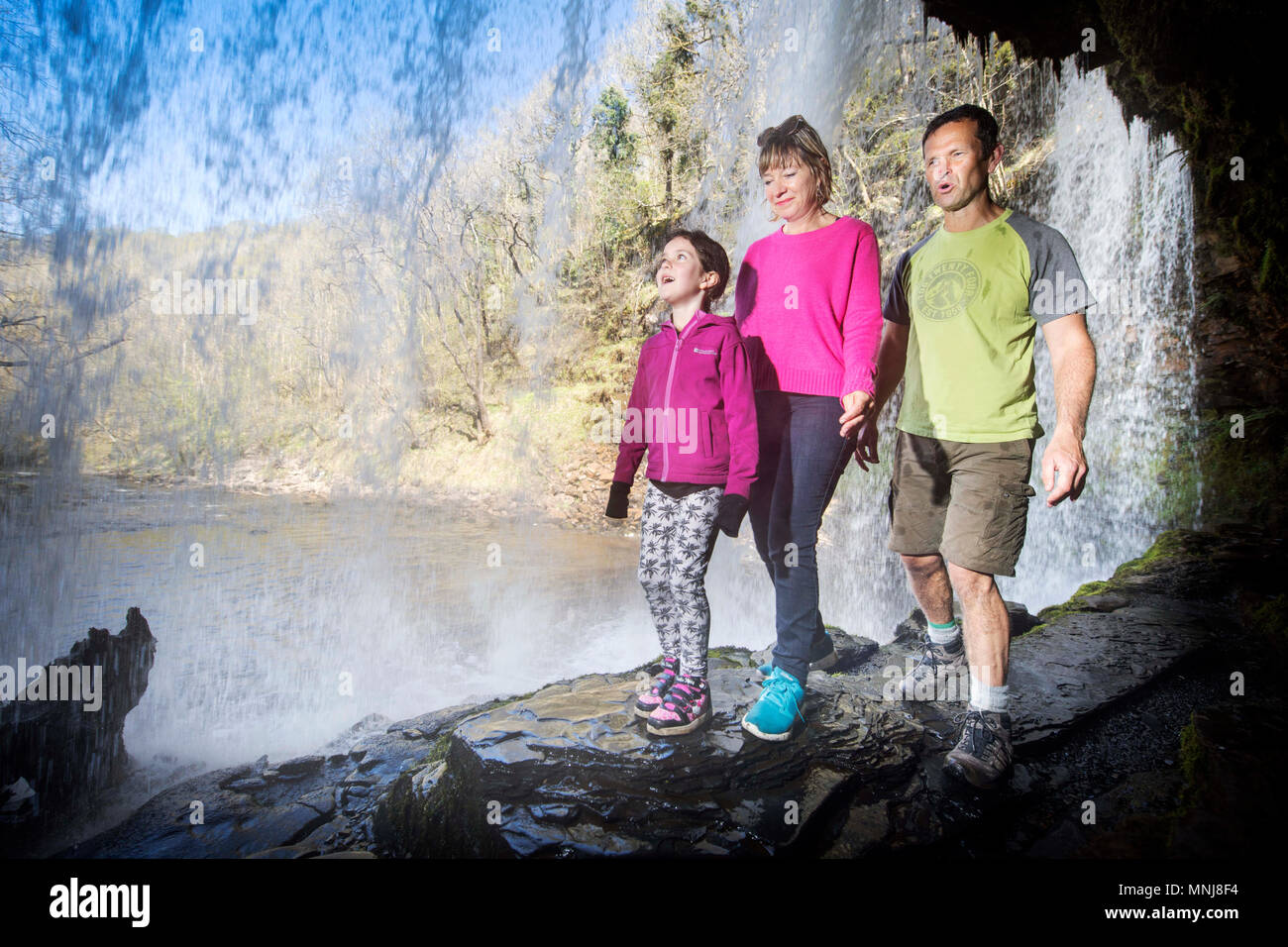 Les quatre cascades à pied près de Pontneddfechan dans les Brecon Beacons - une famille à pied derrière l'Sgwd yr Eira falls (chutes de neige) sur le fleuve Hepste Banque D'Images