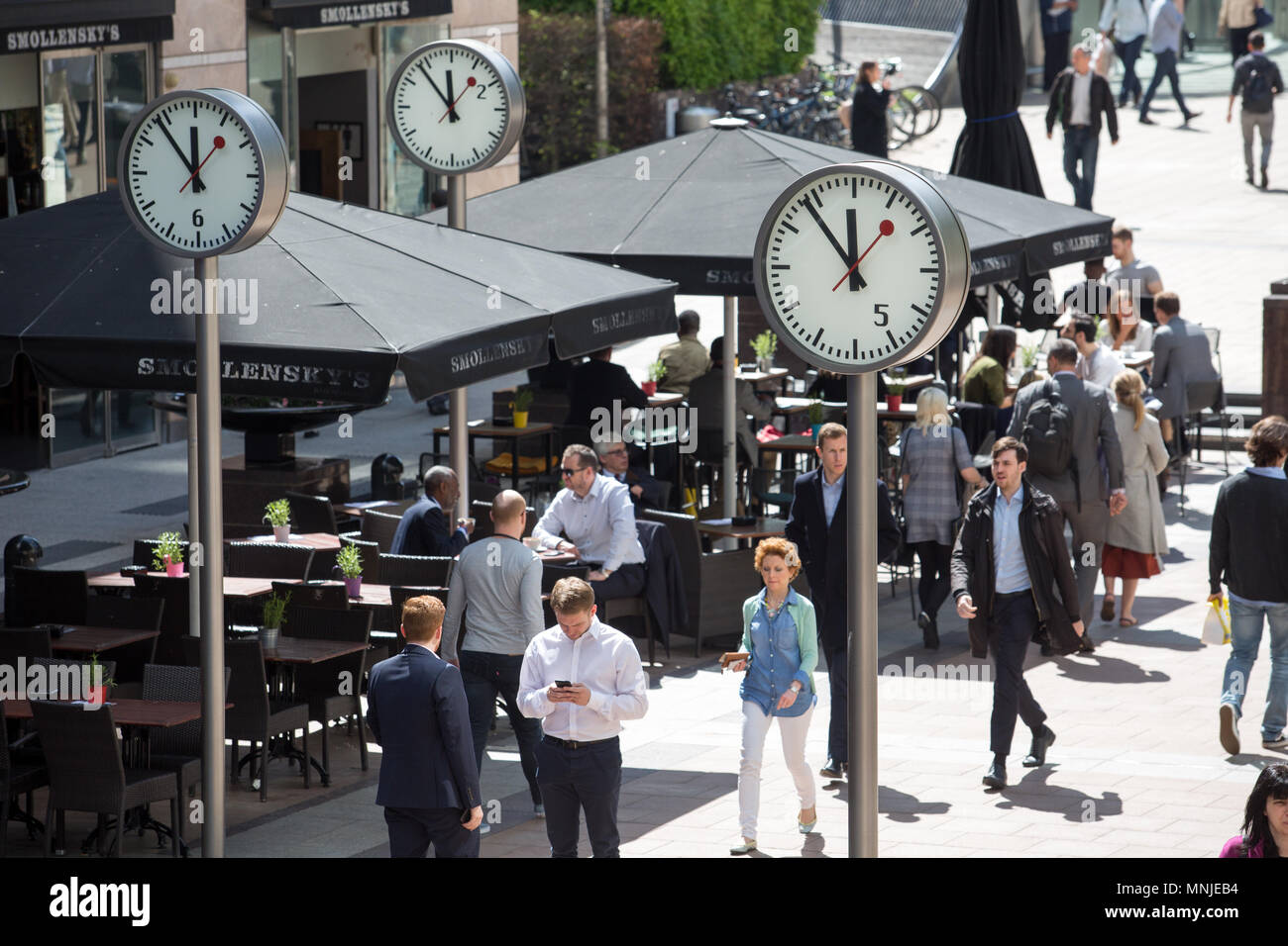 Canary Wharf, horloges indiquent le moment juste avant 12h à l'extérieur de  la station de métro avec les employés autour de la mouture le soleil brille  Photo Stock - Alamy