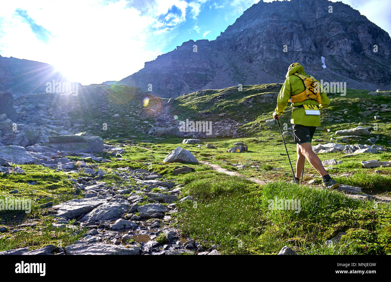 Vue arrière du trail runner walking up chemin de montagne escarpée, Alpe Devero, Verbania, Italie Banque D'Images