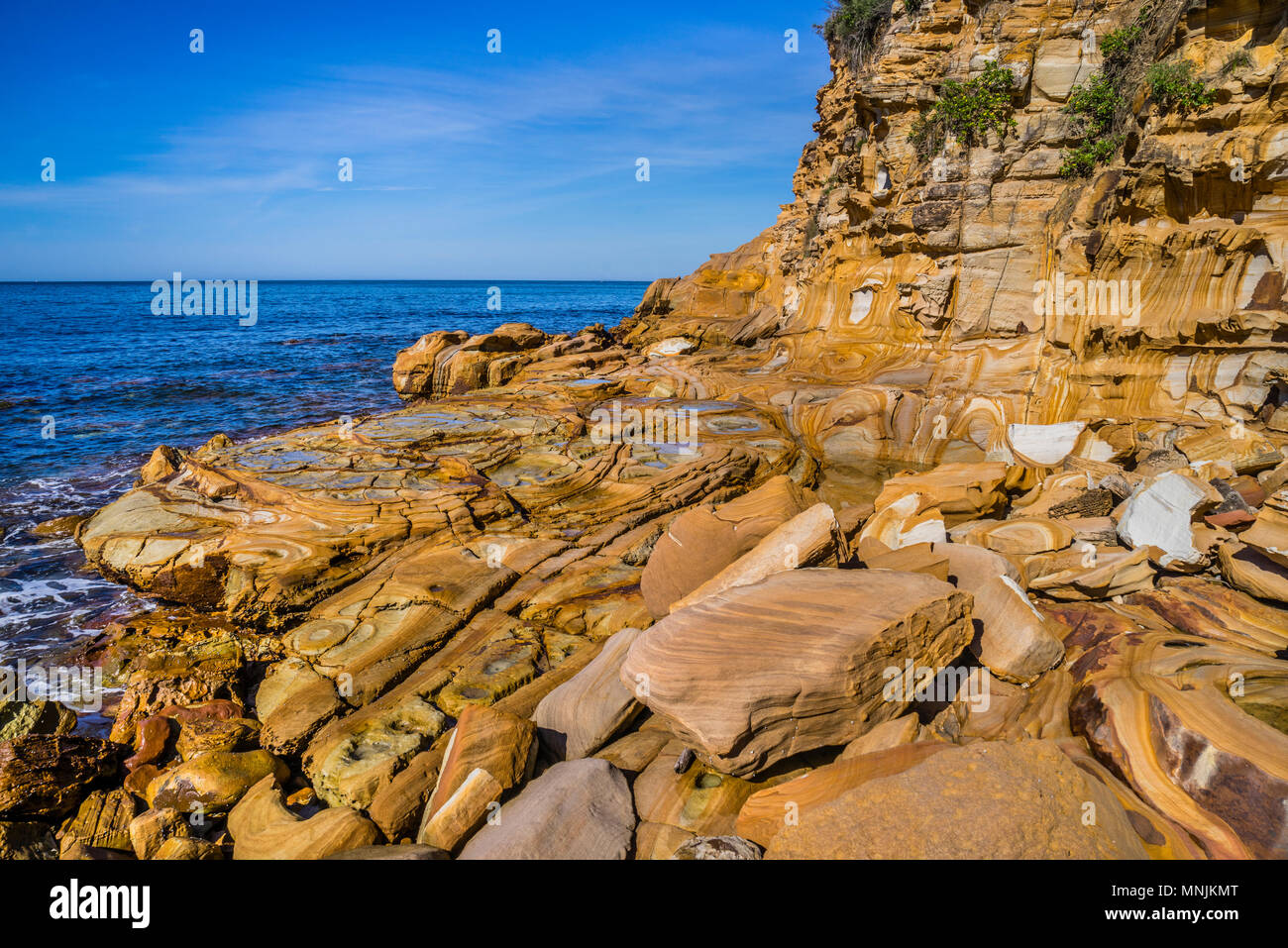 Falaise de grès magnifiquement paterned Hawksbury à Maitland Bay, le brun et d'un marquage de lignes décoratives ont été formées par l'eau et riche en fer sont kn Banque D'Images
