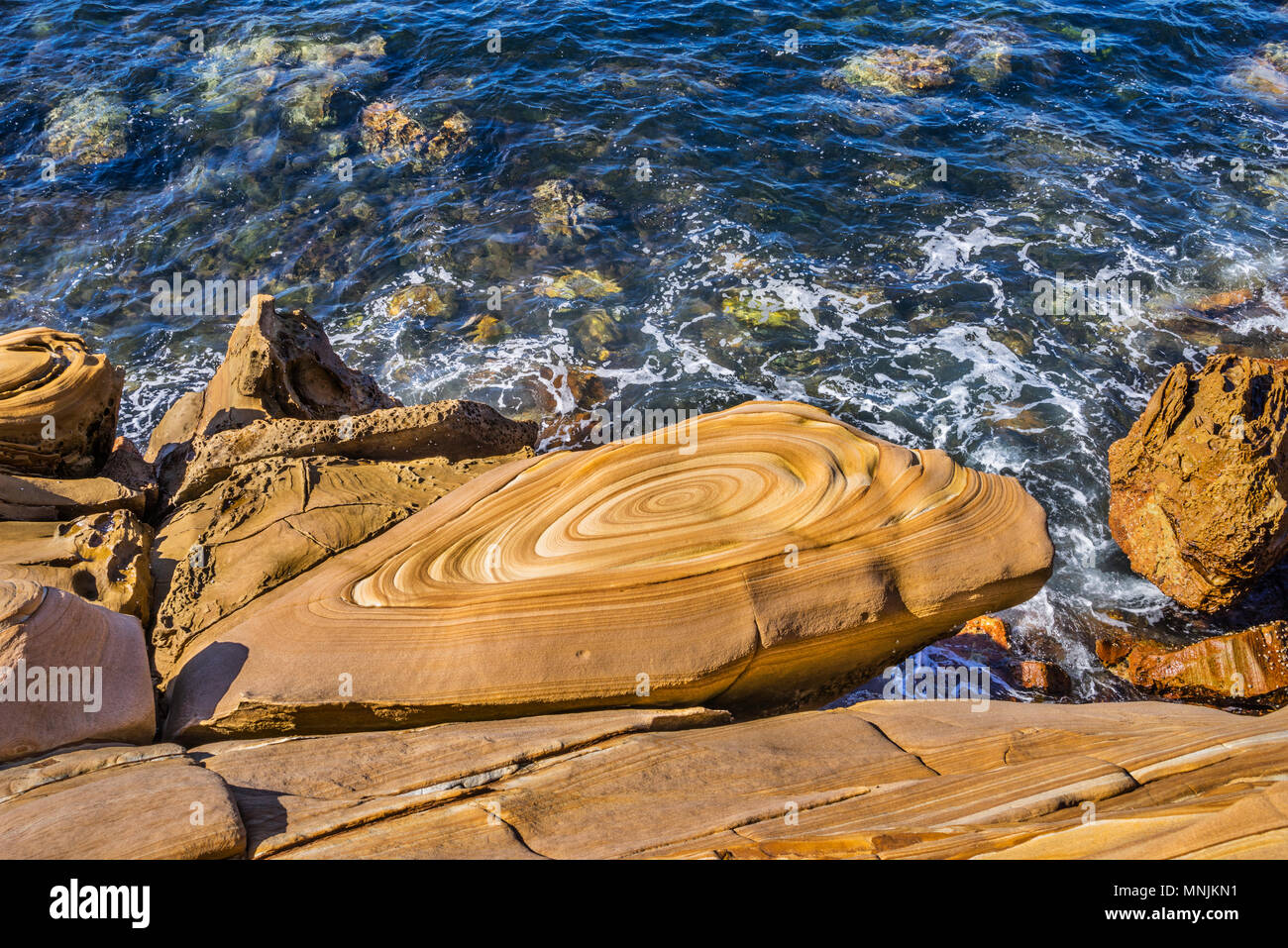 Grès magnifiquement paterned Hawksbury à Maitland Bay, le brun et d'un marquage de lignes décoratives ont été formées par de l'eau riche en fer et sont connus sous le nom de Banque D'Images