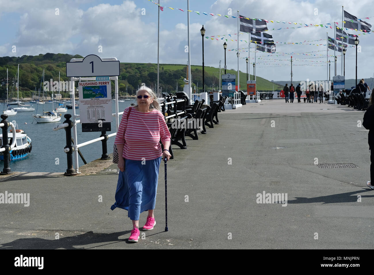Une dame avec un bâton de marche dans la région de Falmouth, Cornwall. Banque D'Images