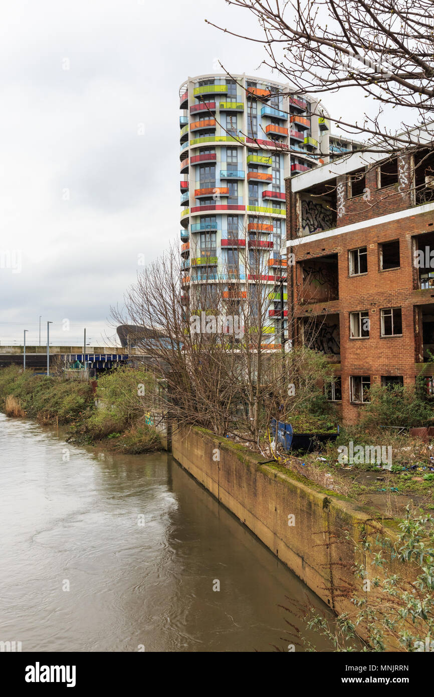 Bâtiment abandonné et nouveau bloc résidentiel moderne, contraste par l'eau de la rivière travaille à Stratford, East London, UK Banque D'Images