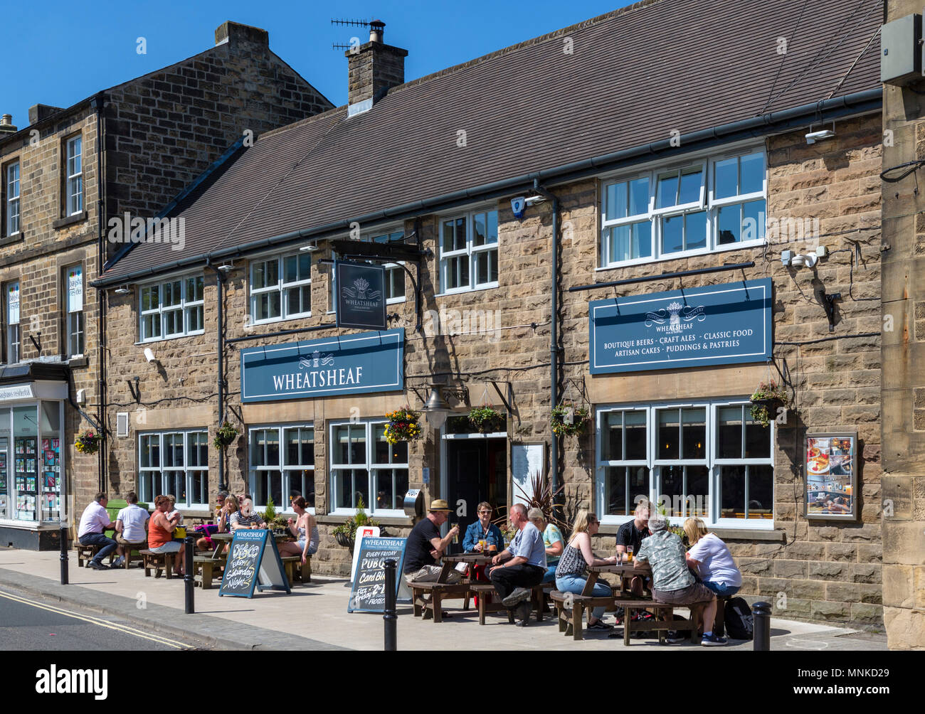 Les gens assis dehors le Wheatsheaf Pub sur Bridge Street dans le centre-ville, Bakewell, Derbyshire, Angleterre, RU Banque D'Images