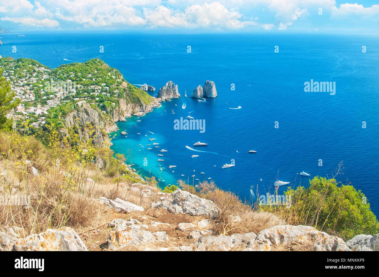 Belle vue de la ville de Capri et les bateaux autour de rochers Faraglioni du haut du mont Solaro, aux beaux jours de l'été, Capri, Italie Banque D'Images