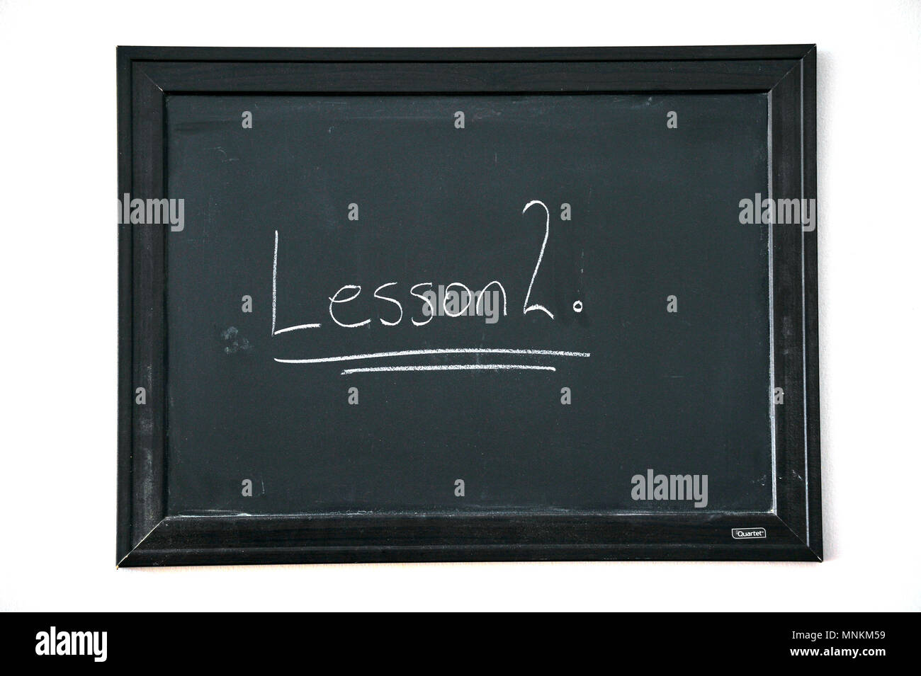 Leçon 2 écrit en craie blanche sur un tableau noir fixé au mur. Banque D'Images