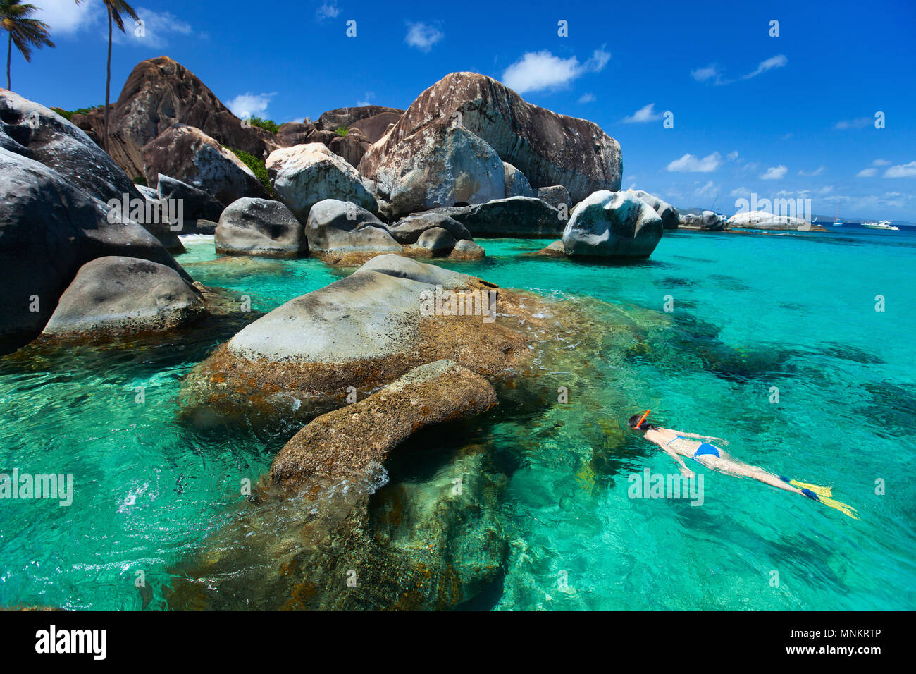 Jeune femme plongée dans l'eau tropicale turquoise entre d'énormes rochers de granit aux bains beach area, British Virgin Islands, Caribbean Banque D'Images