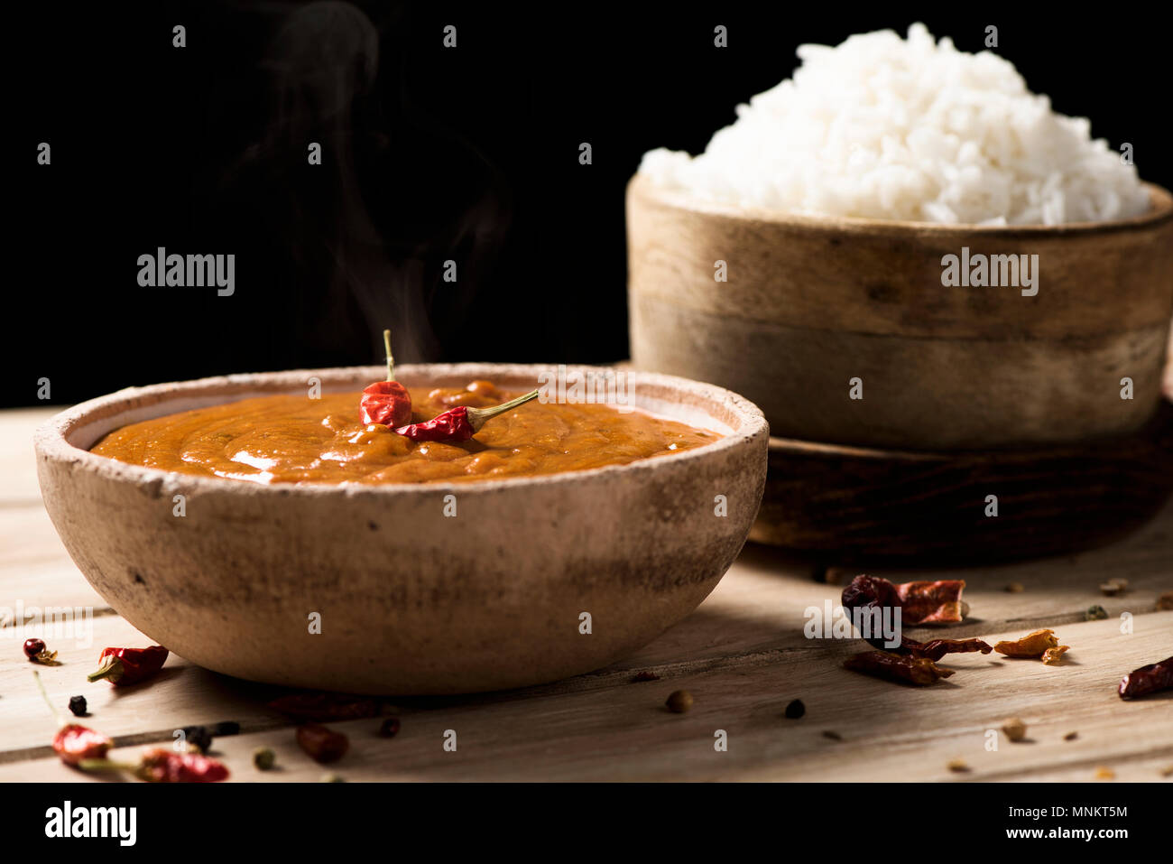 Libre d'un bol avec un poulet korma curry et un bol avec du riz cuit sur une table en bois blanc Banque D'Images
