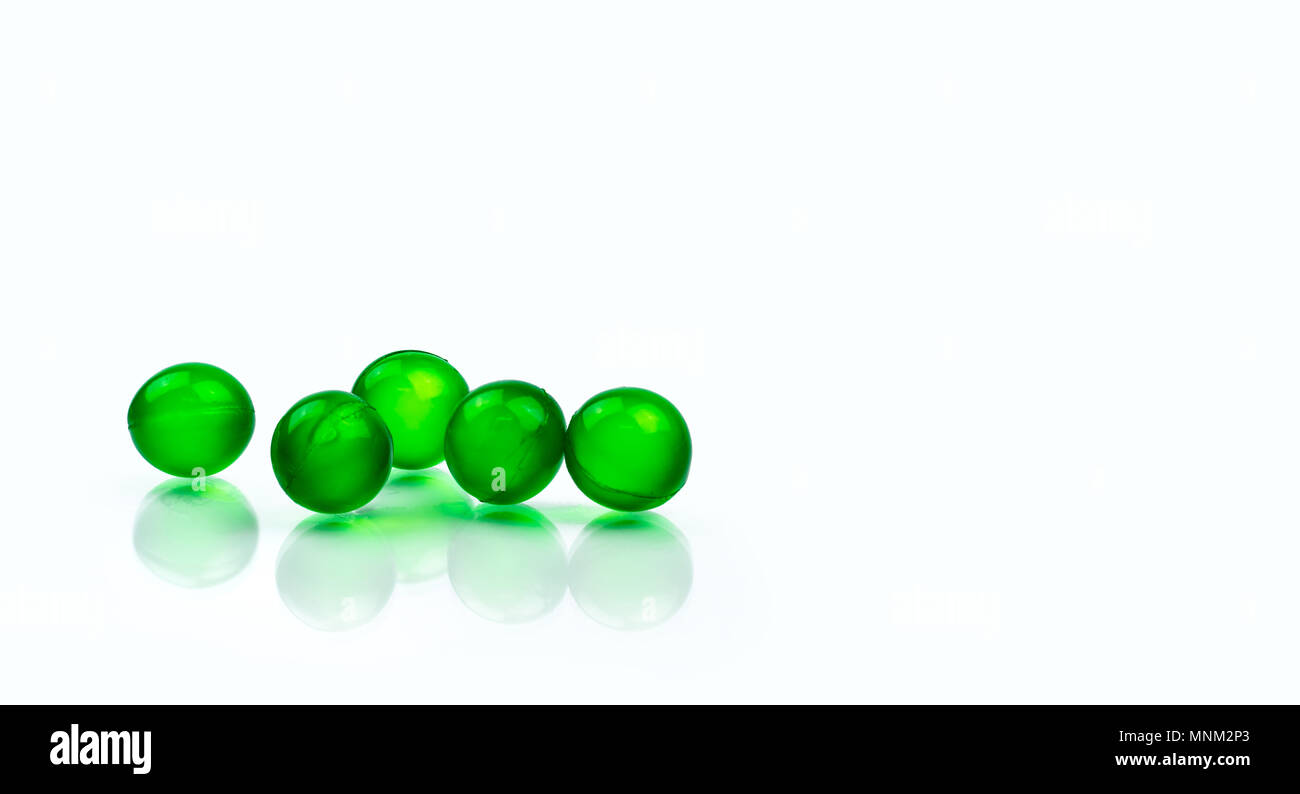 5 capsule molle de rond vert comprimés isolé sur fond blanc avec l'exemplaire de l'espace. La médecine ayurvédique pour l'indigestion, du gaz et de l'acidité. Phytothérapie Banque D'Images