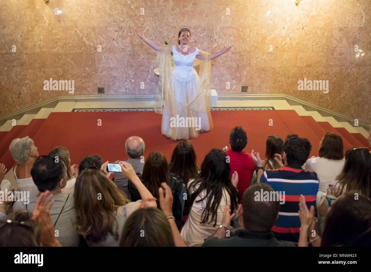 Une chanteuse d'opéra d'effectuer des gestes pour un groupe de touristes en Bateau Viking River à l'Opéra de Budapest à Budapest, Hongrie. Banque D'Images